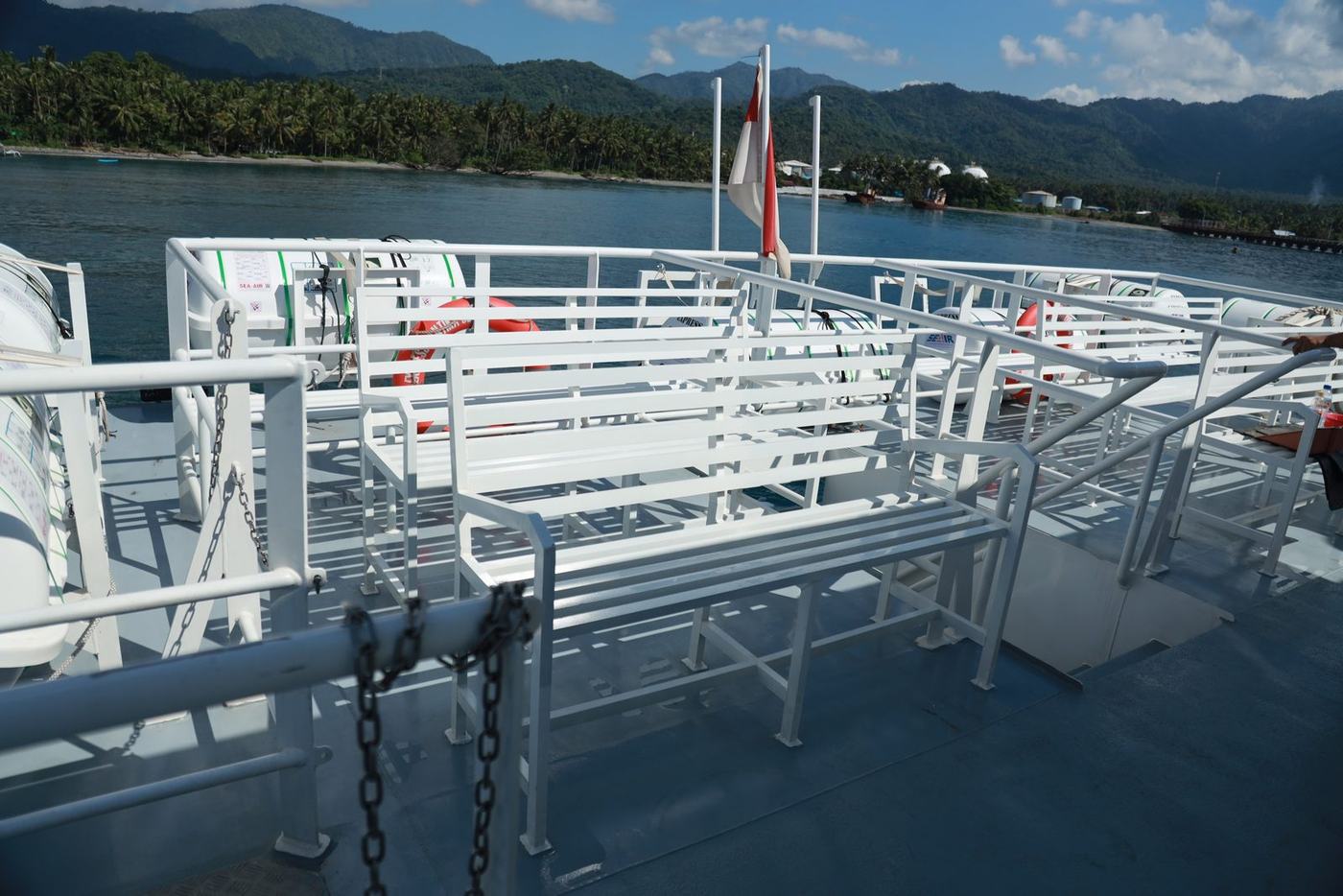 Open-air upper deck seating with the coastline behind