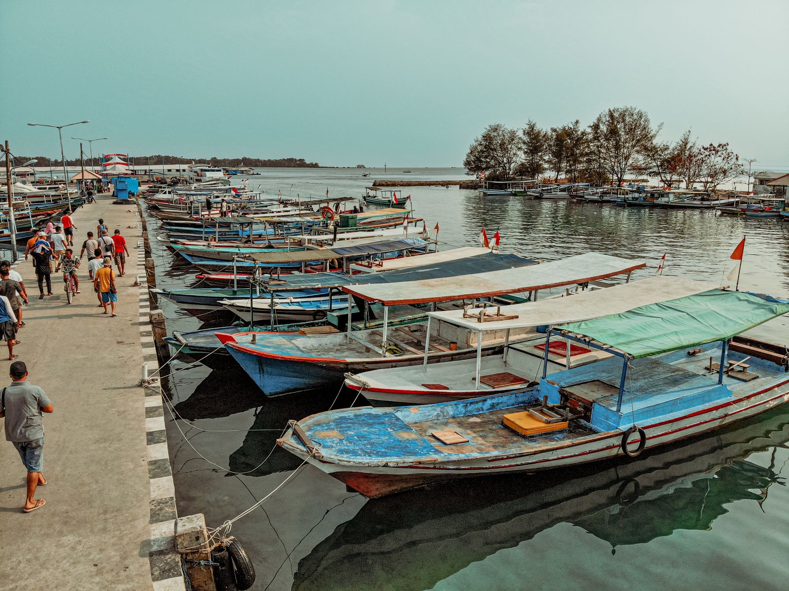 Wooden boats moored along the pier at a Bali harbour