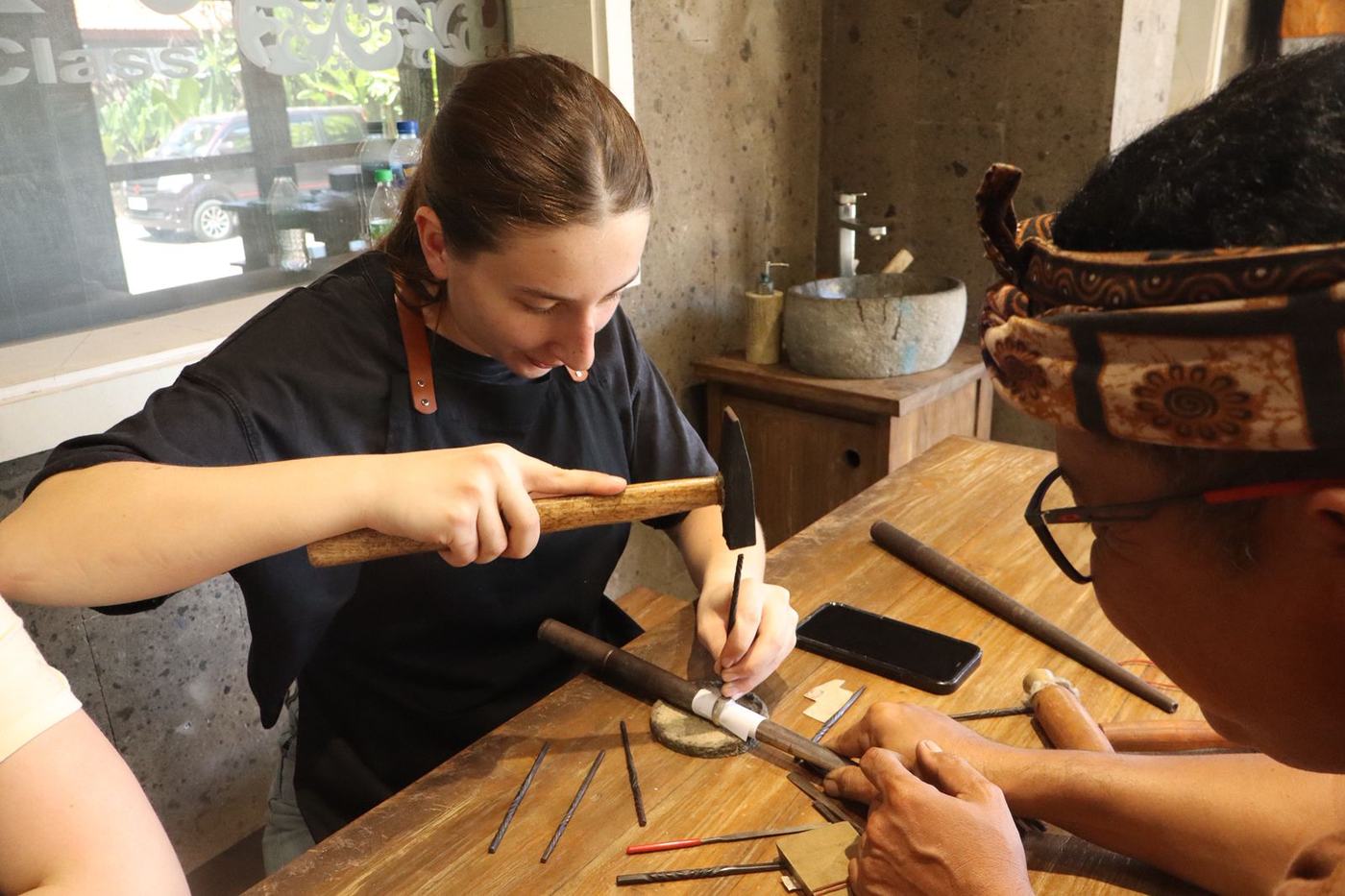 Silversmith shaping a ring at her workbench