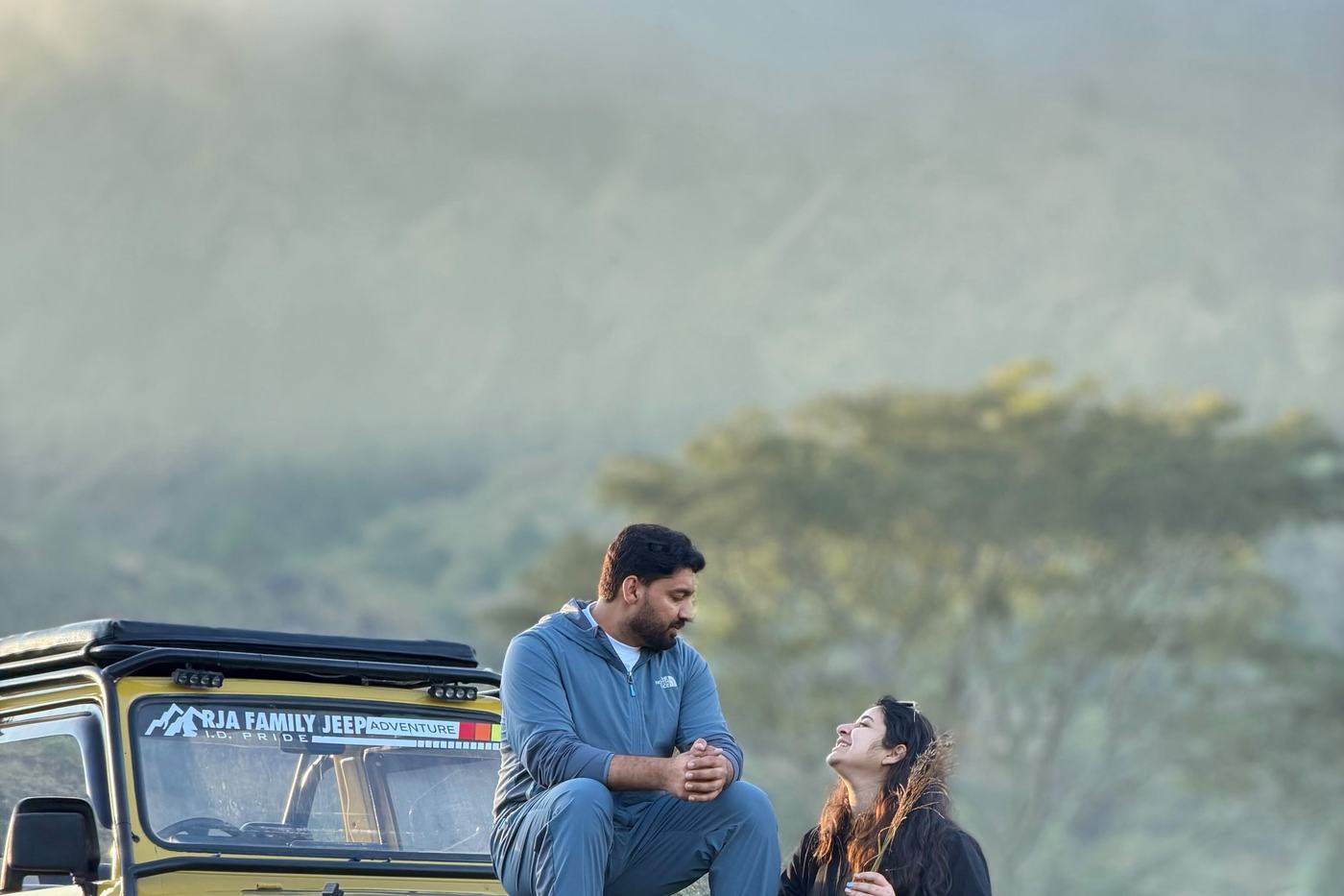 Guests on a jeep looking out over the misty highlands
