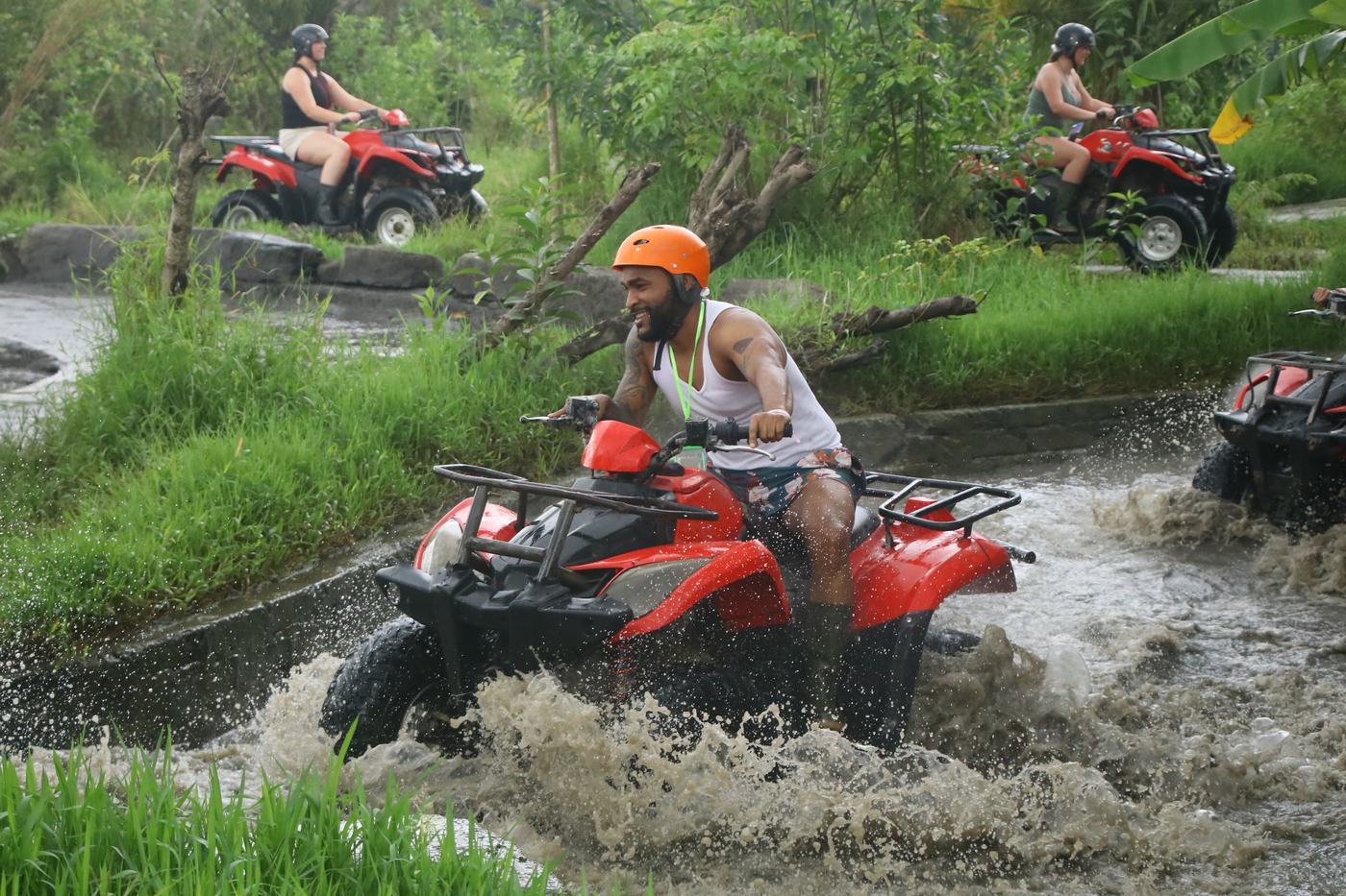 Guest riding an ATV through a muddy jungle track