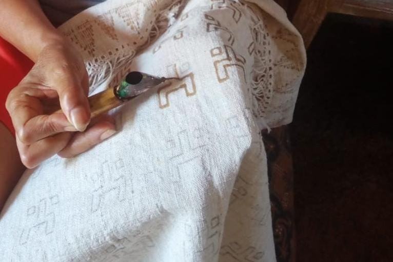 Batik artisan drawing hot wax onto white cloth