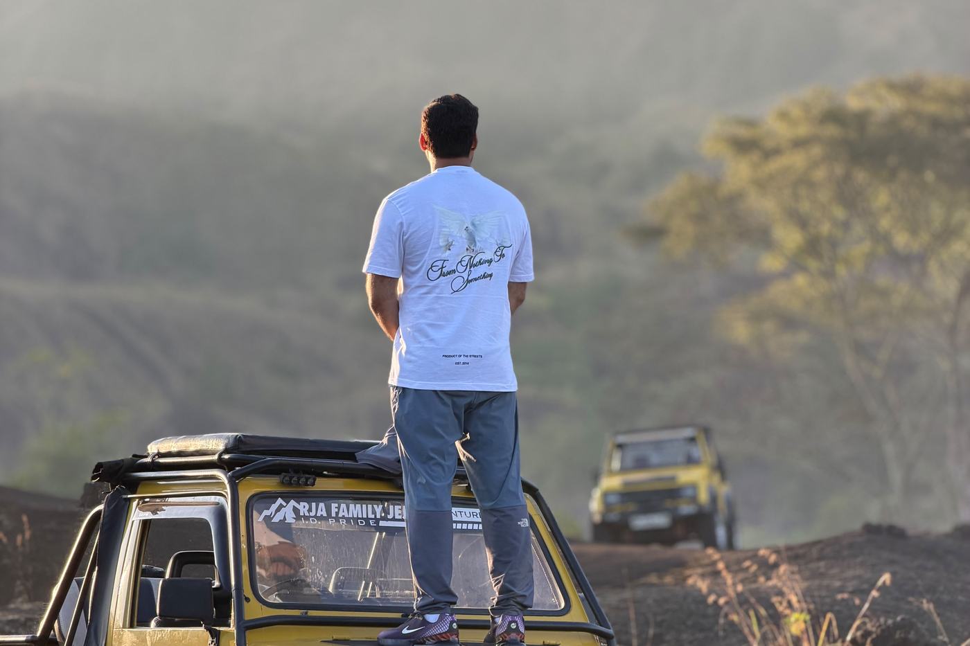 Guest standing on a jeep watching sunrise over the highlands