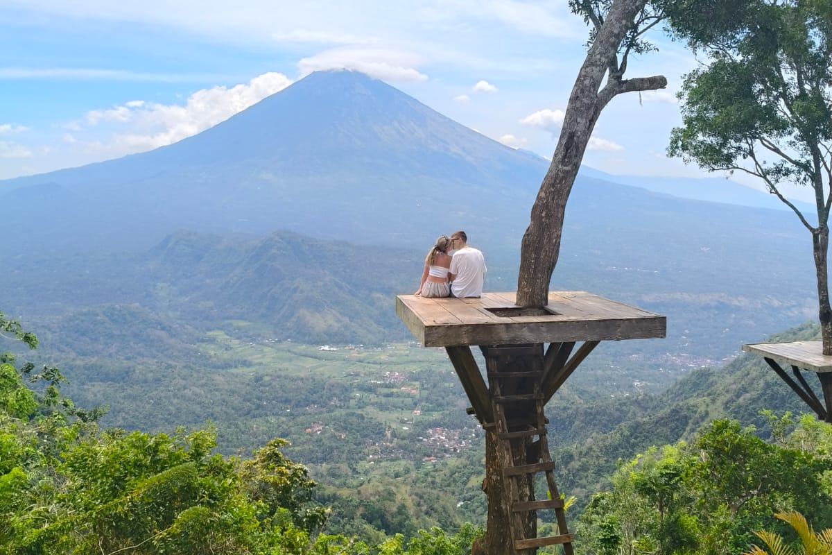 Guest on a tree platform looking across to the volcano