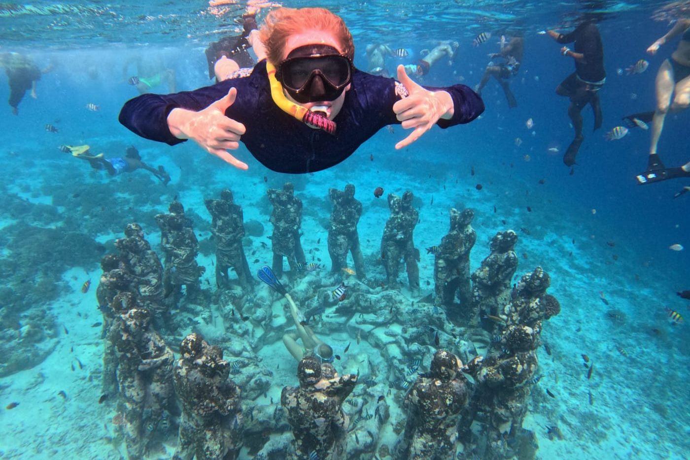 Snorkeller above The Nest underwater statues off Gili Meno